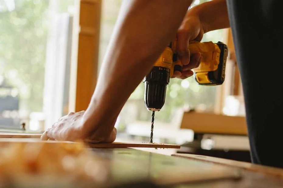 Person using a drill to fix a timber component in a GEORGE Group service image