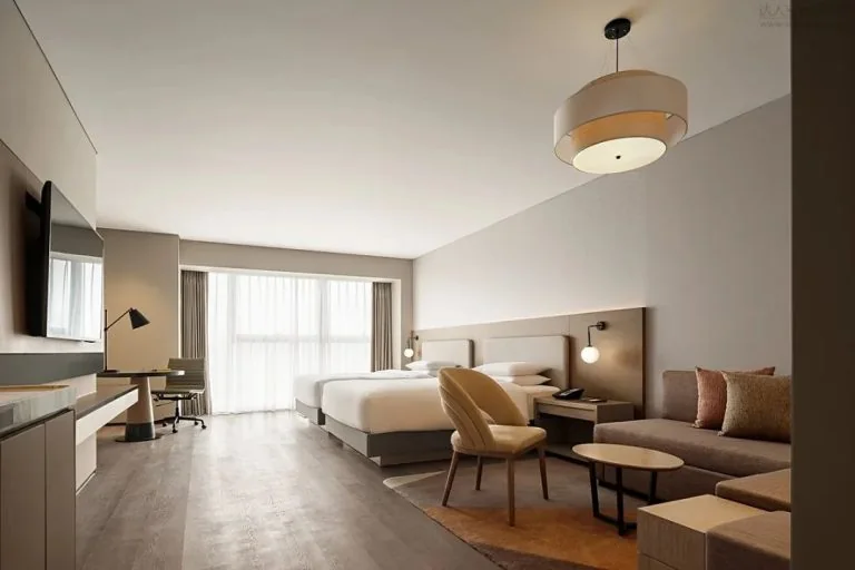 Hotel room with bed, sofa, chair, tables and kitchenette area