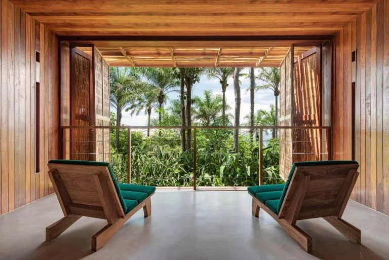 Covered timber terrace with two lounge chairs facing a landscaped area