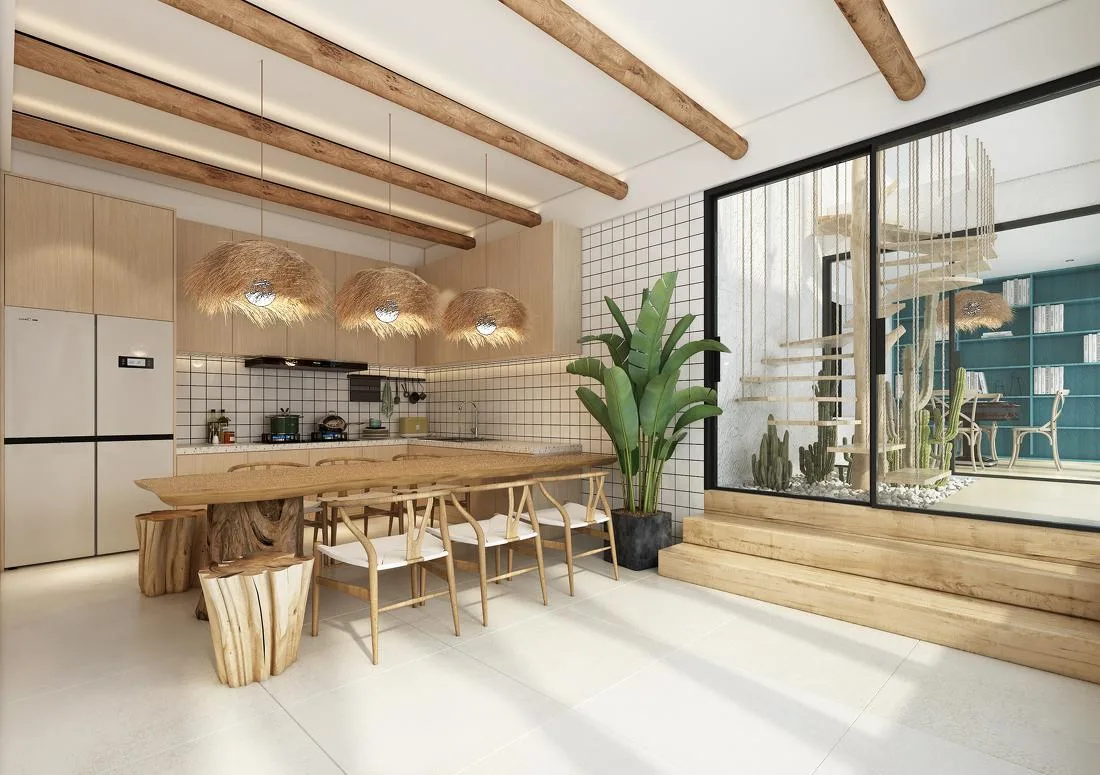 Bright dining and kitchen area with timber beams, long table and pendant lights