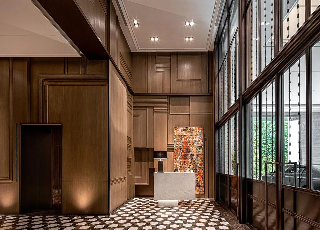 Hotel foyer with timber wall panels, patterned floor and reception podium