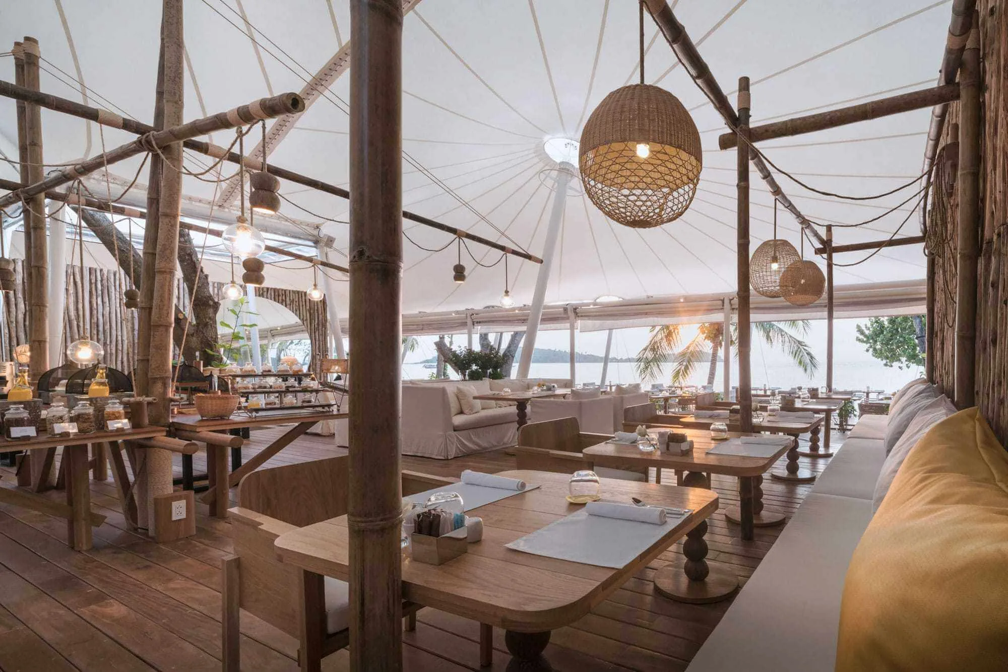 Open beach-resort restaurant with timber tables, rope details and pendant lights