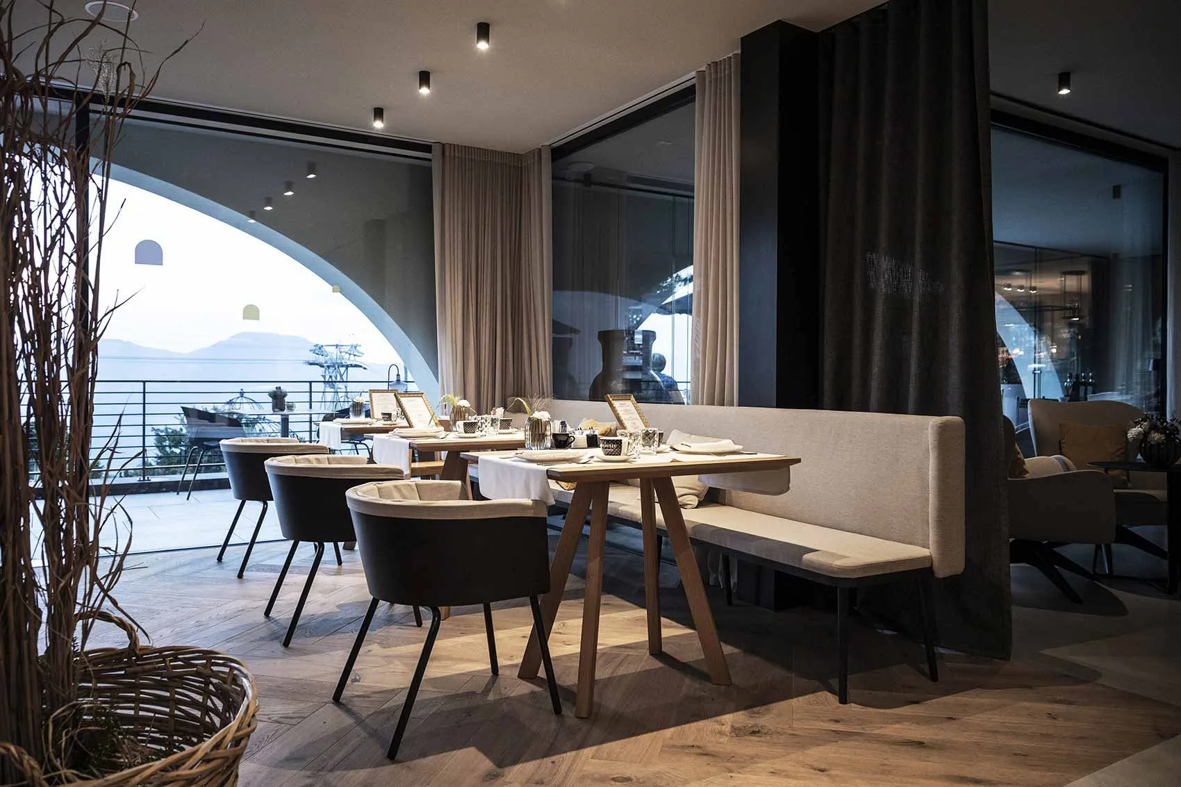 Restaurant seating beside a large arched opening to the terrace