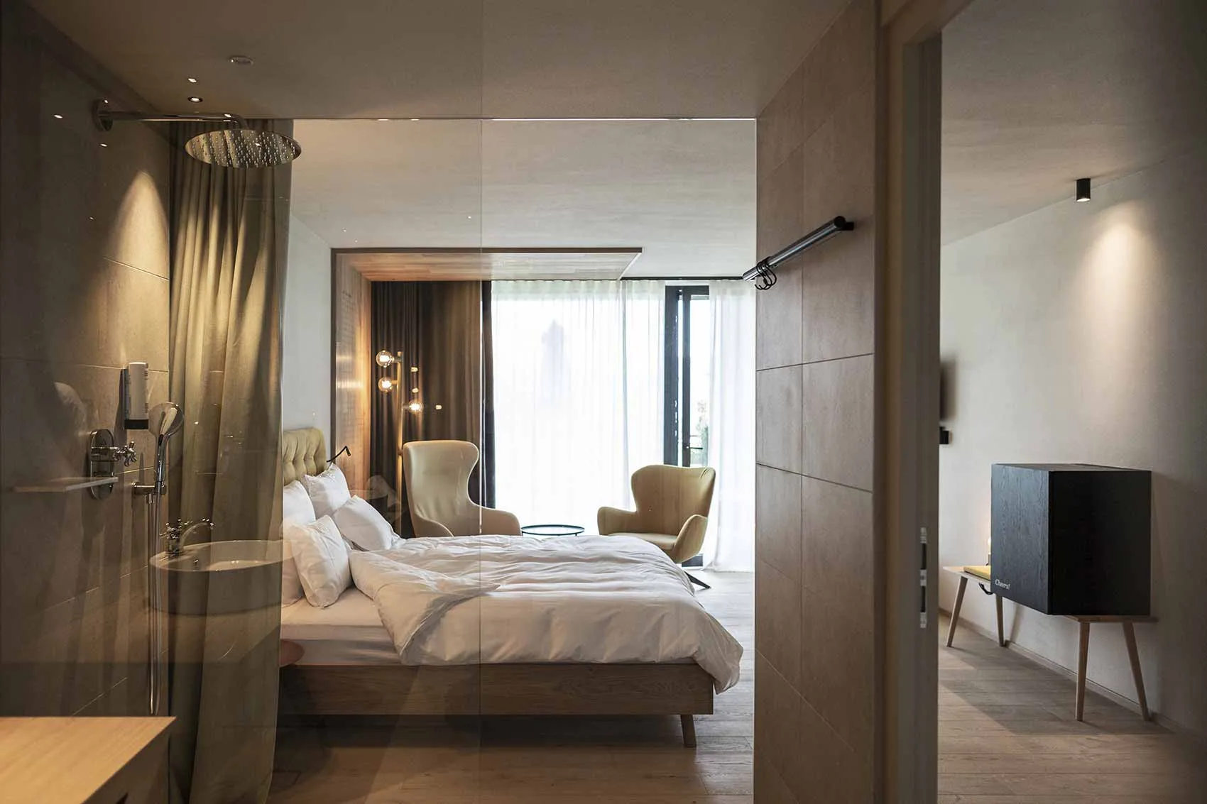 Guest bedroom with bed, desk and terrace glazing
