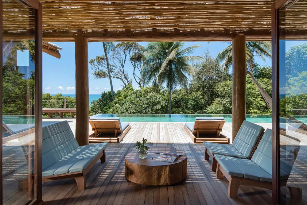 Covered terrace with low tables, chairs and tropical view