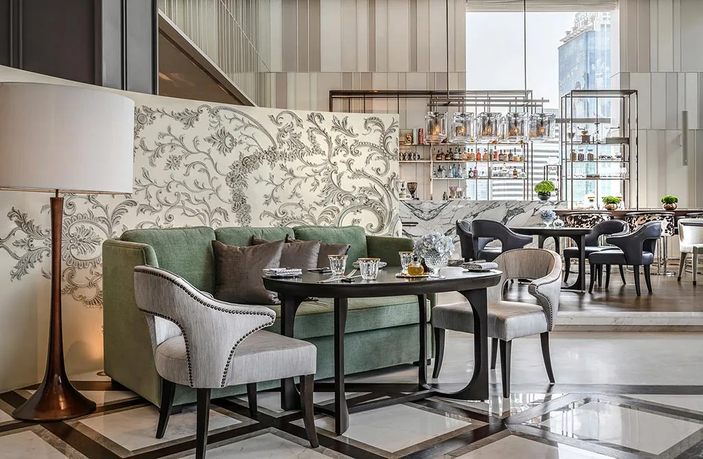Restaurant seating area with upholstered chairs and patterned screens