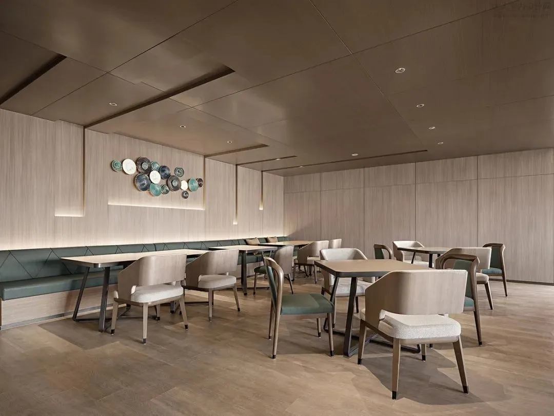 Restaurant seating area with pale chairs, tables and a service counter
