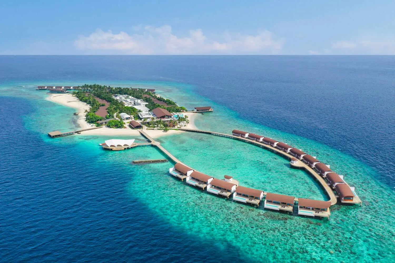 Aerial day view of the island resort and over-water villas