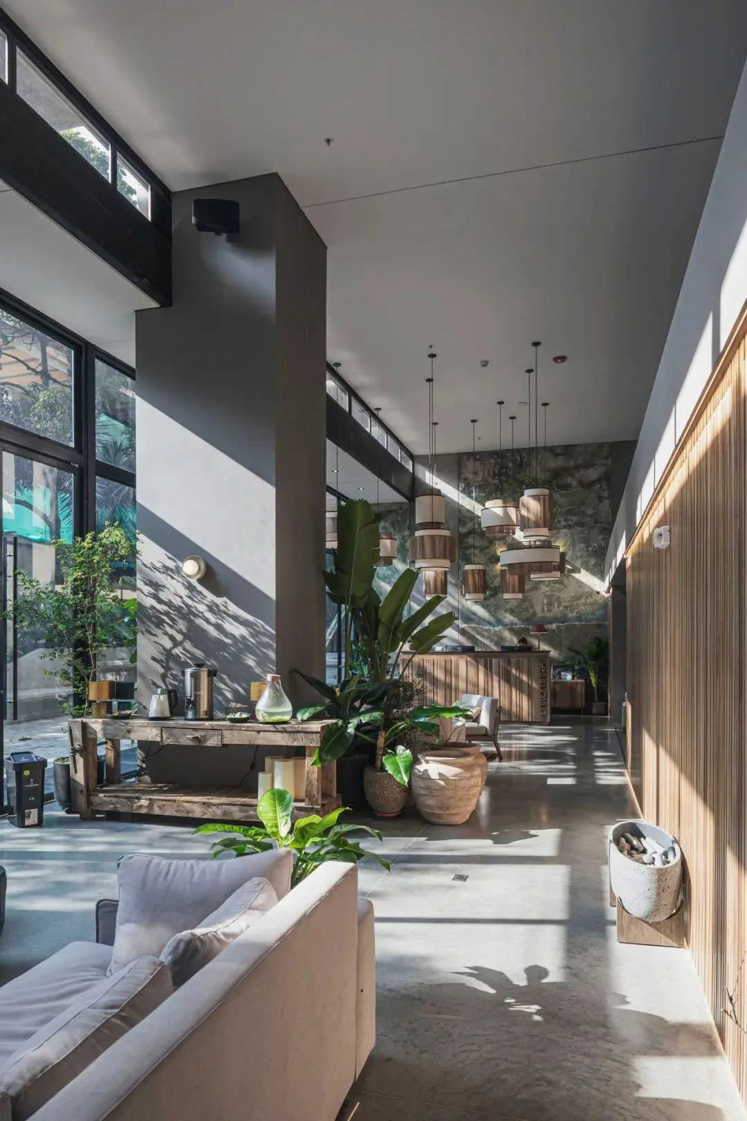 Double-height guest lounge with seating and a suspended sculptural light