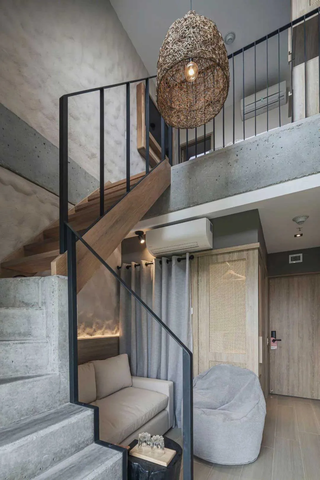 Duplex guest-room corner with stair, bed and lounge chair
