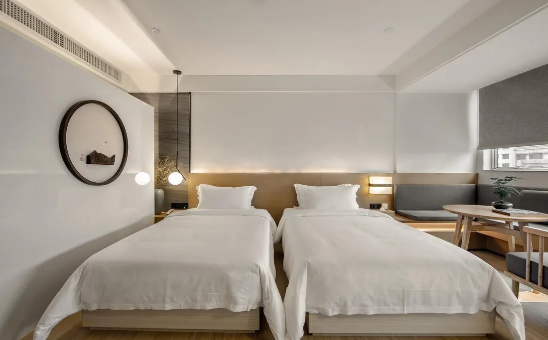 Twin guest room with two beds, shared headboard and long desk