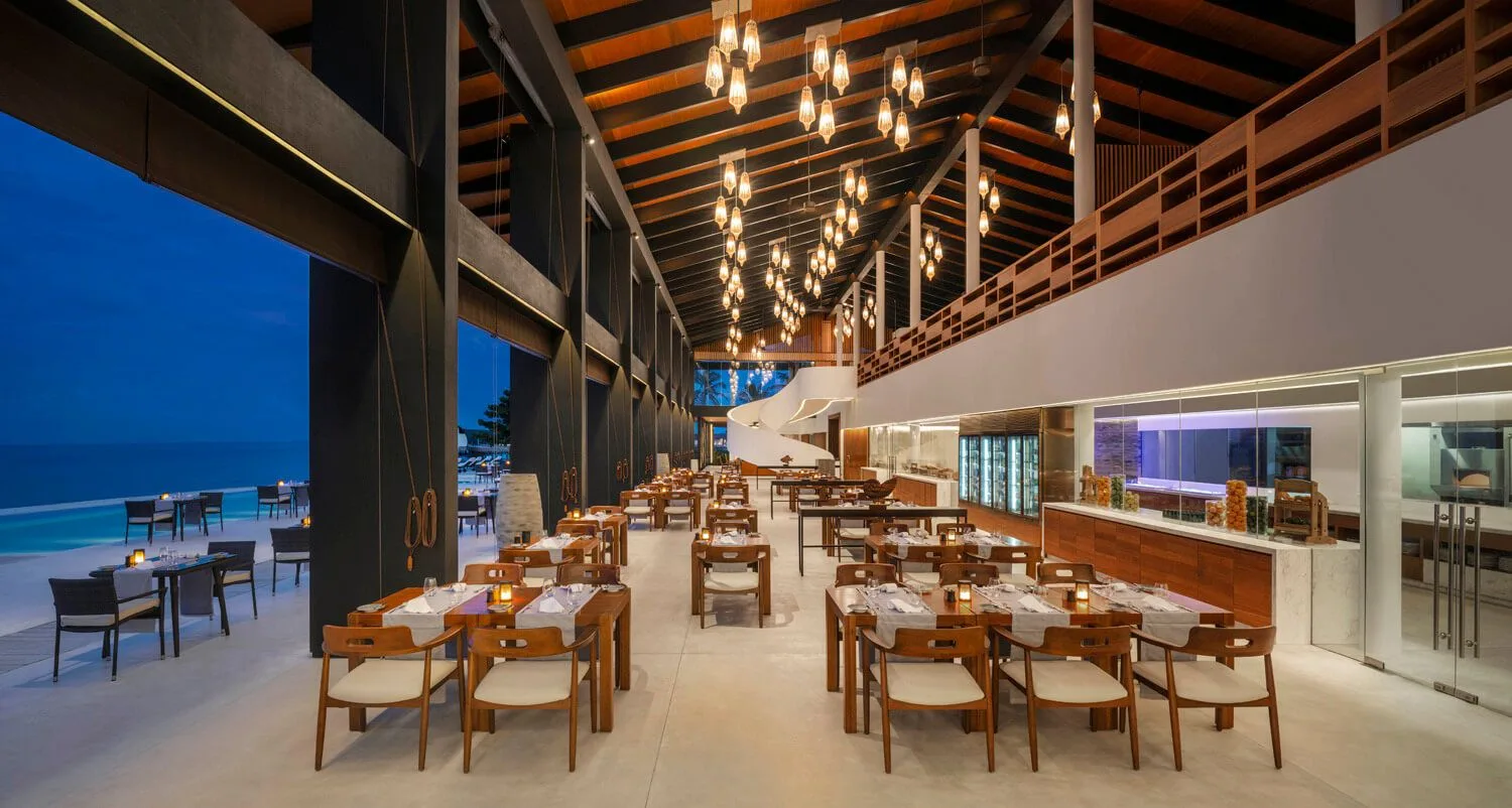 Open restaurant with timber roof, dining tables and ocean-facing edge