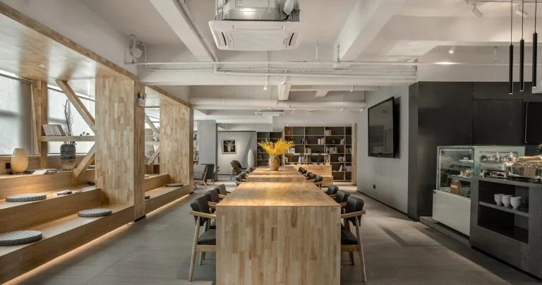 Open kitchen and shared dining counter with stools and overhead lighting