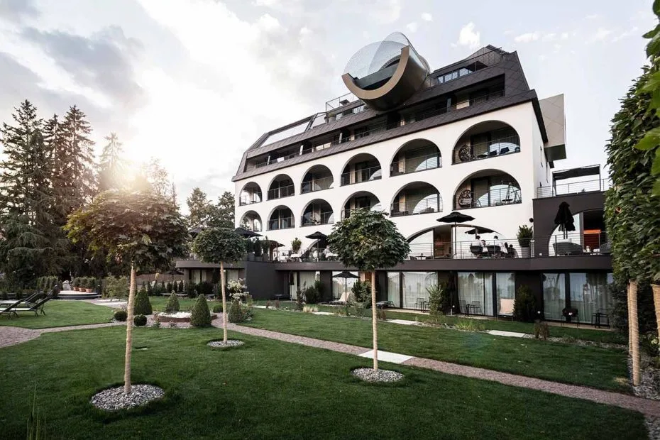 Gloriette Hotel exterior with arched guest-room openings, terraces and a landscaped lawn